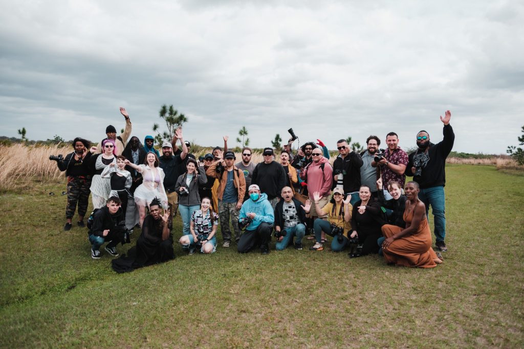 pexels photo 16018046 16018046 A diverse group of photographers posing together in a natural setting with cameras.